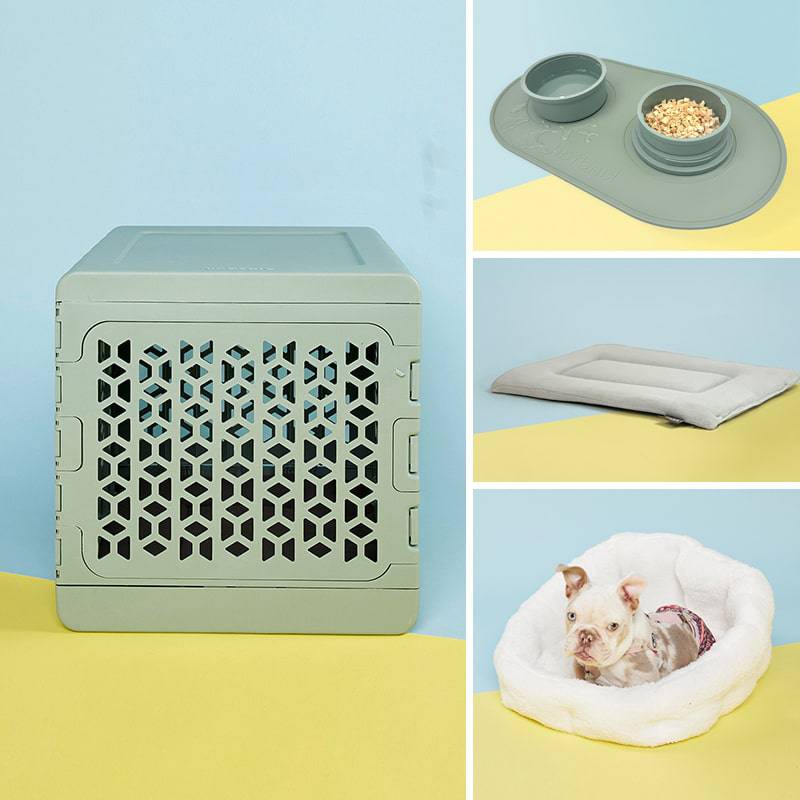 White crate with a pink mat with a grey dog inside, dog bed, pink dog bowl and silicone mat for the bowls.